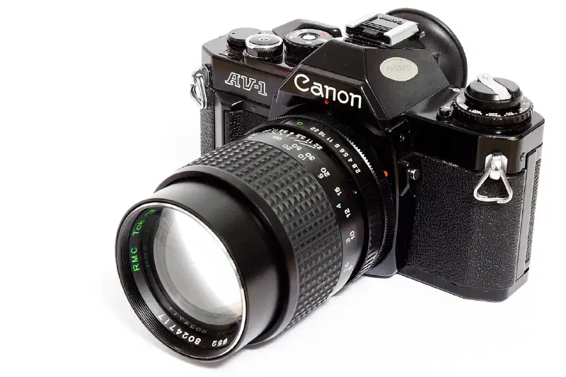 Home studio shot of a Canon AV-1 analog camera with a tokina 135mm f2.8 lens.