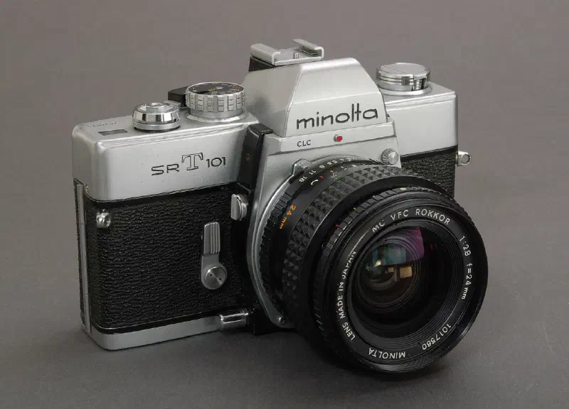 Minolta SRT 101 in der ersten Ausführung ohne X-Kontakt im Zubehörschuh, mit Knebel zur manuellen Spiegelarretierung