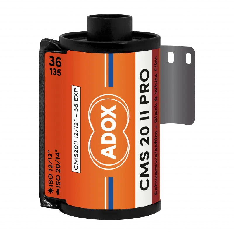 A 35 mm cassette of ADOX CMS 20 II PRO, leader out, orange label with the ADOX double-circle mark, marked ISO 12/12° in daylight and ISO 20/14° in tungsten, 36 exposures