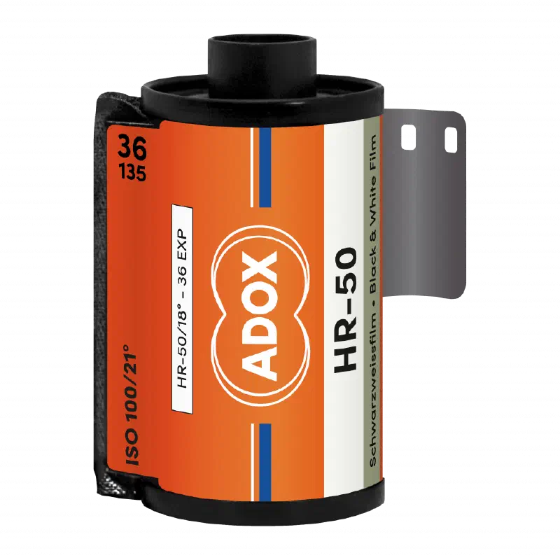 A 35 mm cassette of ADOX HR-50, leader out, orange label with the ADOX double-circle mark, marked HR-50/18°, 36 exposures, Schwarzweissfilm