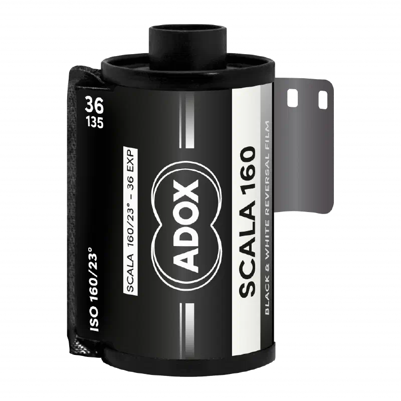 A 35 mm cassette of ADOX SCALA 160, leader out, black label with the ADOX double-circle mark, marked ISO 160/23°, 36 exposures, black & white reversal film