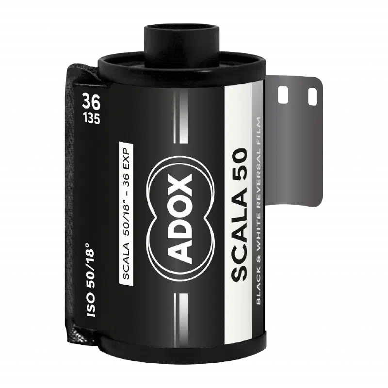 A 35 mm cassette of ADOX SCALA 50, leader out, black label with the ADOX double-circle mark, marked ISO 50/18°, 36 exposures, black & white reversal film
