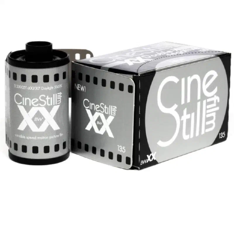 A 35 mm cassette of CineStill BwXX beside its black and grey 135 box
