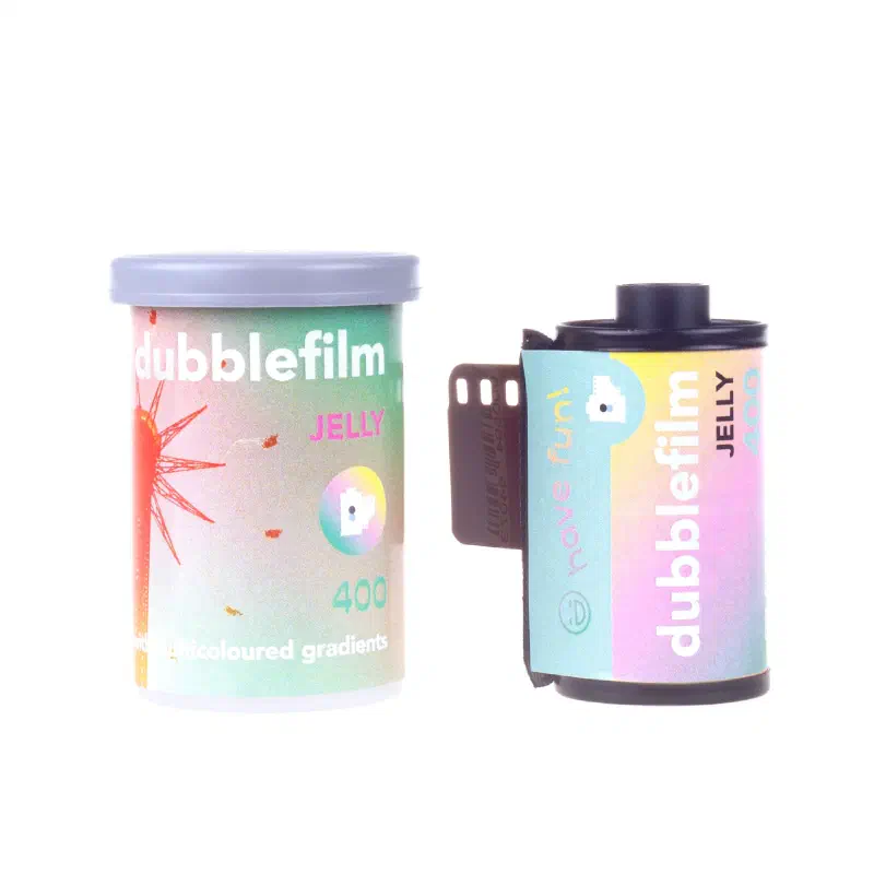 A dubblefilm Jelly 400 canister and 35 mm cassette on white, the canister showing a pastel sunburst