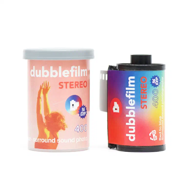 A dubblefilm Stereo 400 canister and 35 mm cassette on white, the canister showing a figure with raised arms in red and yellow