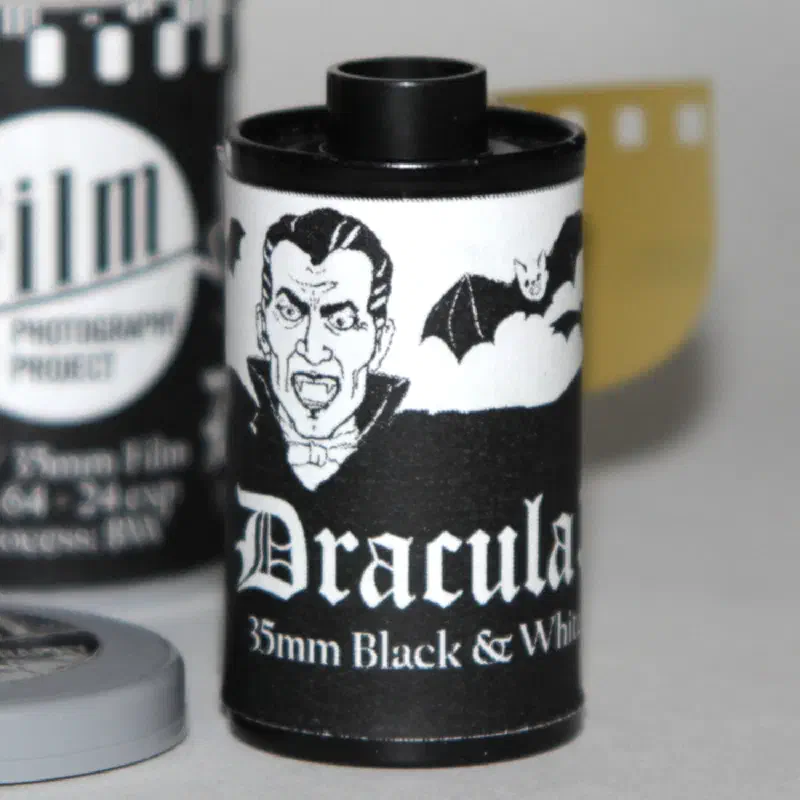 A black 35 mm cassette lettered Dracula in white script beneath an engraved vampire and bat, marked 35mm Black & White, iso 64, 24 exp