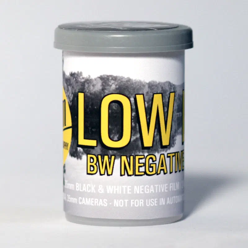 A 35 mm canister lettered LOW ISO in yellow over a grey landscape, marked 35mm BLACK & WHITE NEGATIVE FILM and NOT FOR USE IN AUTOMATIC CAMERAS
