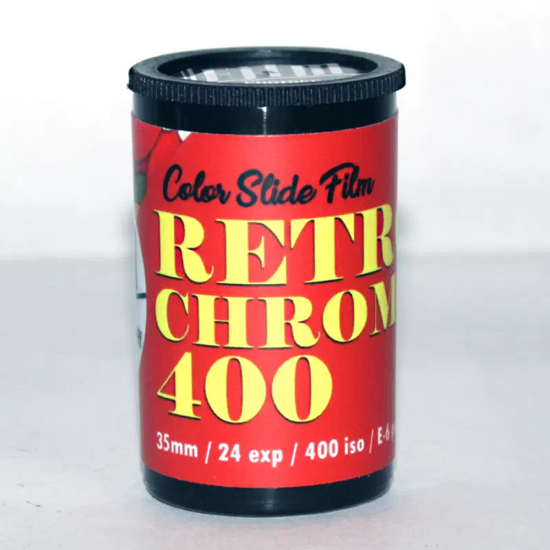 A red 35 mm canister lettered RETROCHROME 400 in yellow under the words Color Slide Film, marked 35mm / 24 exp / 400 iso