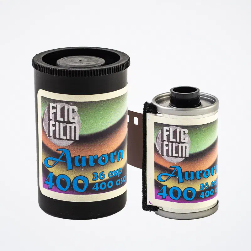 A 35 mm canister and cassette of FLIC FILM Aurora 400 side by side, aurora-banded label over a starfield, marked 36 exp 400 asa