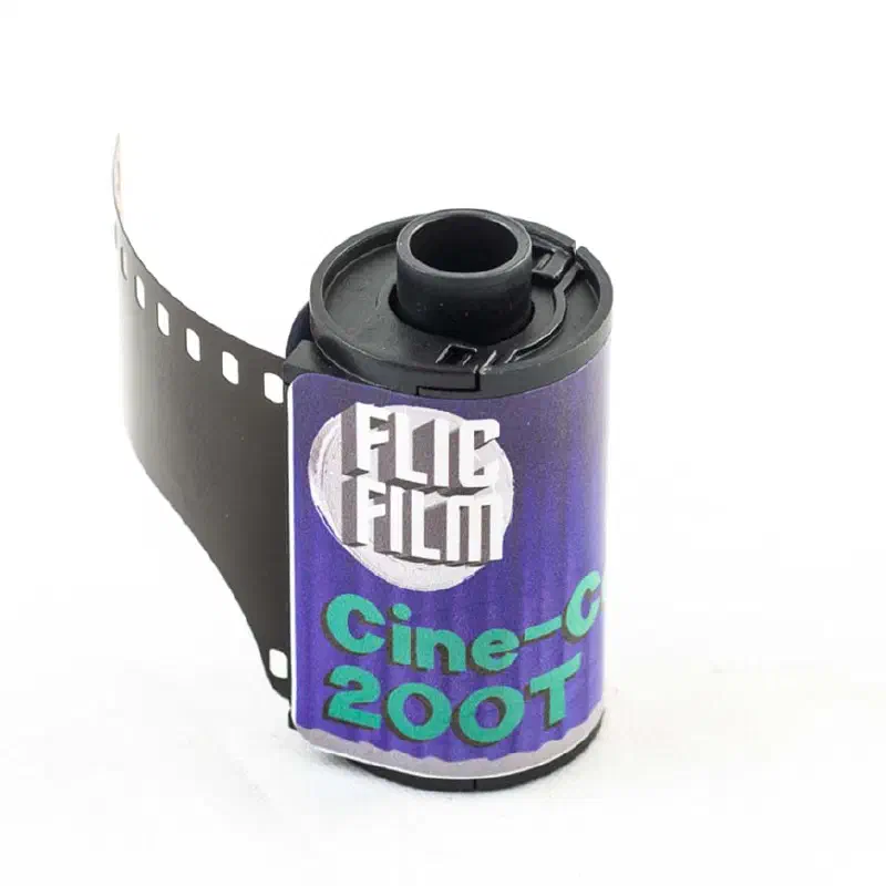 A 35 mm cassette of FLIC FILM Cine-Color 200T with its leader out, violet label lettered in green