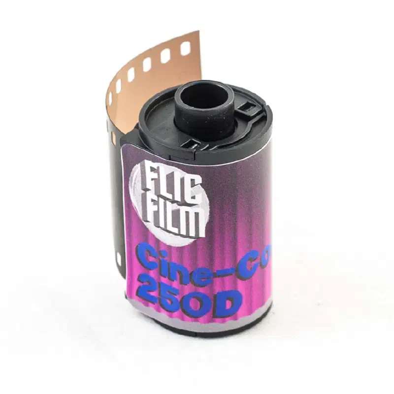 A 35 mm cassette of FLIC FILM Cine-Color 250D with its leader out, magenta label lettered in blue