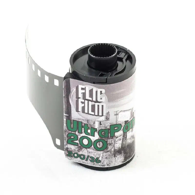 A 35 mm cassette of FLIC FILM UltraPan 200 with its leader out, a black-and-white photograph printed on the label, marked 200/36