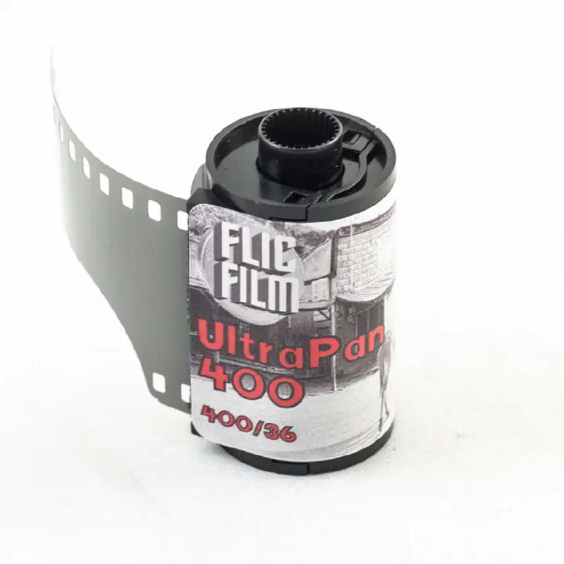 A 35 mm cassette of FLIC FILM UltraPan 400 with its leader out, a black-and-white photograph printed on the label, marked 400/36