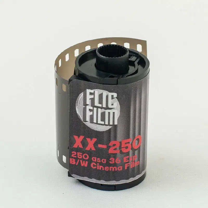 A 35 mm cassette of FLIC FILM XX-250 with its leader out, grey label lettered in red, marked 250 asa 36 Exp B/W Cinema Film