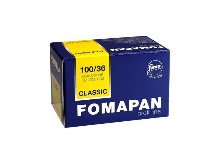 A navy FOMAPAN profi line carton seen from a front corner, a yellow panel on its end marked 100/36 and CLASSIC