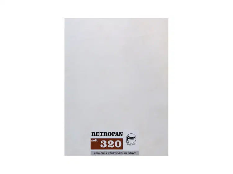 A white RETROPAN sheet-film envelope standing upright, a small maroon label at its foot marked 320
