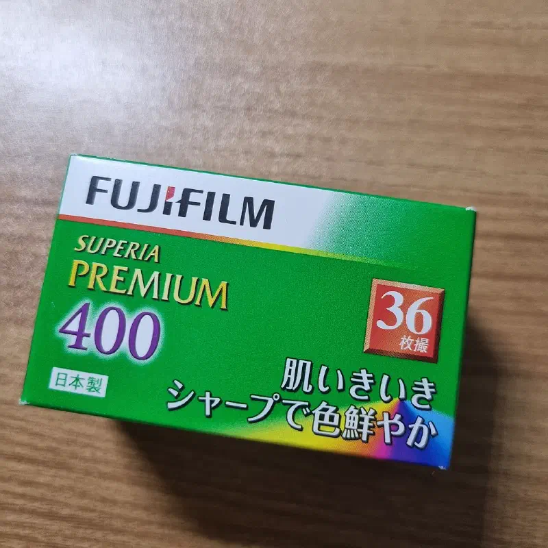 A green and white FUJIFILM SUPERIA PREMIUM 400 carton seen from a front corner, marked 36 exposures and lettered in Japanese