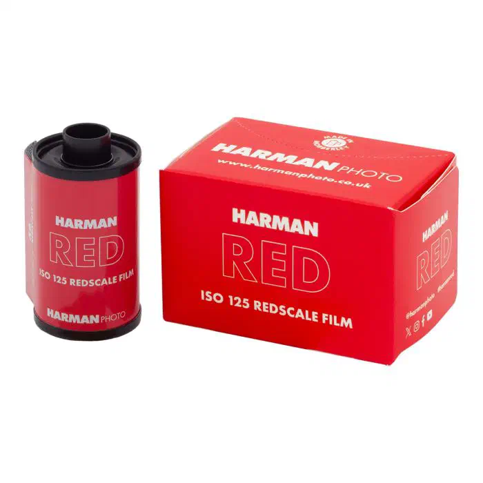A 35 mm cassette of HARMAN RED beside its scarlet carton, marked ISO 125 REDSCALE FILM