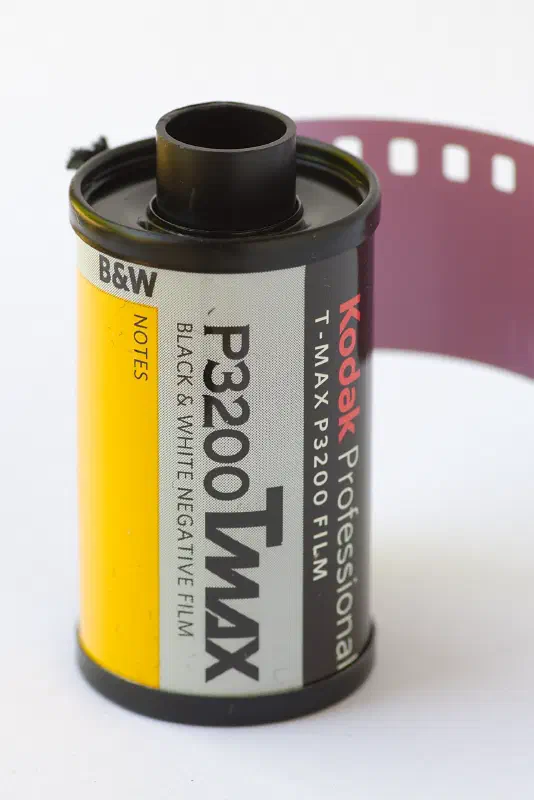 A 35 mm cassette of KODAK Professional T-MAX P3200 with its leader out, yellow and black label marked BLACK & WHITE NEGATIVE FILM