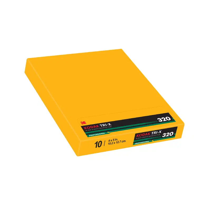 A yellow KODAK TRI-X 320 sheet-film box lying flat, black band with a green stripe and a PROFESSIONAL flash, marked 10 sheets 4 x 5 in.