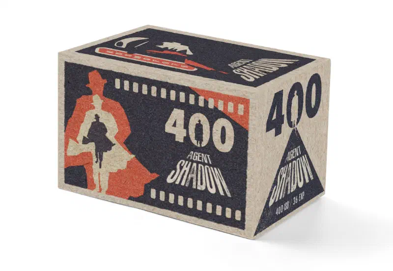 A kraft, black and red Kosmo Foto Agent Shadow 400 box, printed with a trench-coated figure