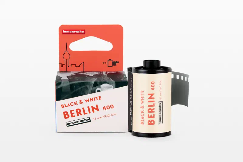 A red and cream Berlin 400 Black & White carton beside its 35 mm cassette and leader, marked 35 mm KINO Film