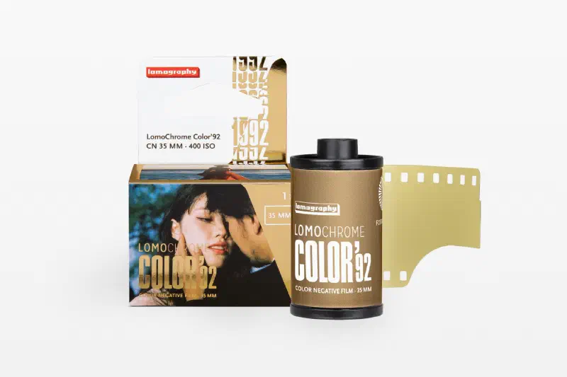 A gold LomoChrome Color '92 carton beside its 35 mm cassette and leader, marked CN 35 MM · 400 ISO