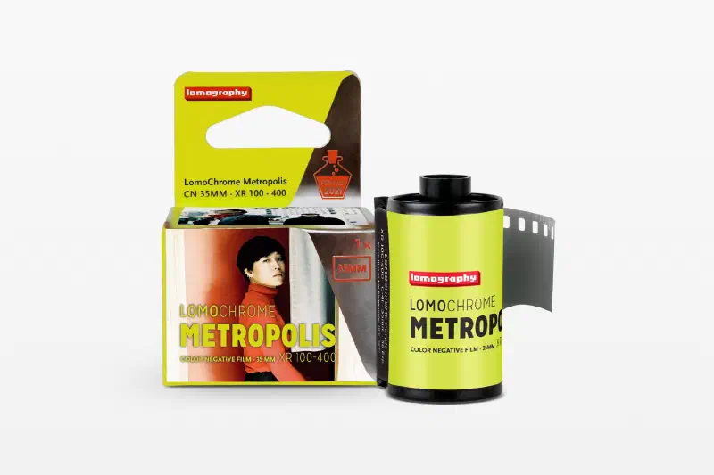 A yellow-green LomoChrome Metropolis carton beside its 35 mm cassette and leader, marked CN 35MM · XR 100-400