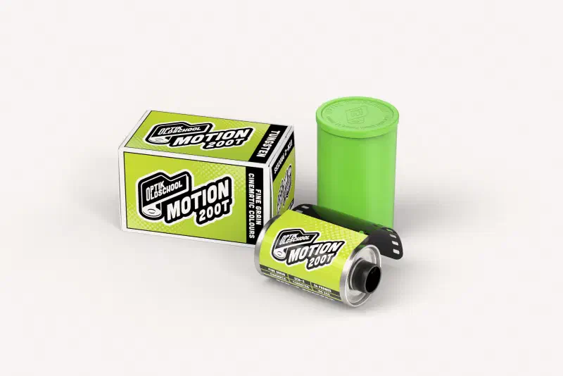 A green Optik Oldschool Motion 200T box beside a 35 mm cassette and a green canister