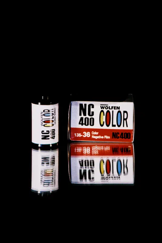 A WOLFEN NC 400 COLOR carton and its 35 mm cassette on black, both white with a red band, marked 135-36 and Process C-41