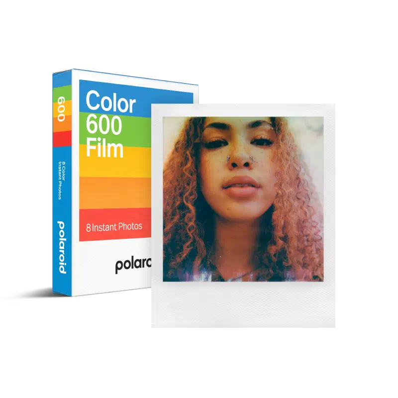 A white Polaroid Color 600 Film box seen from a front corner, its rainbow stripe across the face and 8 Instant Photos at the foot, a developed portrait of a woman leaning against it