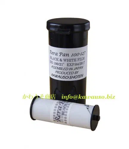 A 127 roll of Rera Pan 100 standing upright, its black-and-white label facing the camera