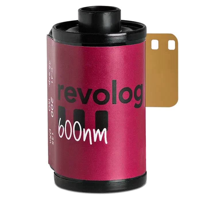 A 35 mm cassette of revolog 600nm on a green ground, its label a crimson-to-purple gradient lettered in white, leader out