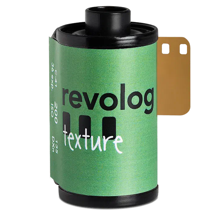 A 35 mm cassette of revolog texture on a green ground, its label a green gradient lettered in white, leader out
