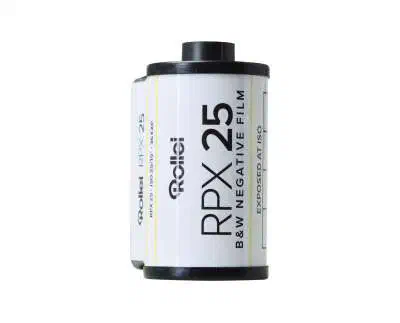 A 35 mm cassette of Rollei RPX 25, white label with a yellow stripe, marked B&W NEGATIVE FILM and EXPOSED AT ISO